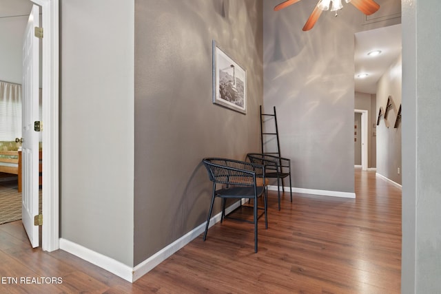 corridor featuring baseboards and wood finished floors