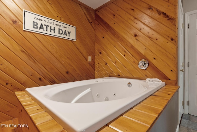 bathroom featuring wooden walls and a whirlpool tub