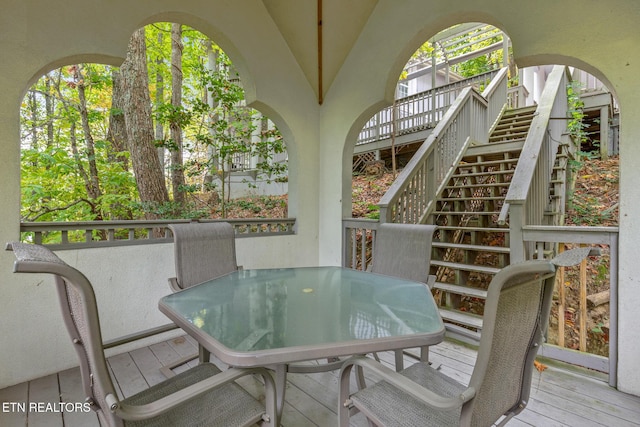 wooden deck with outdoor dining space and stairs