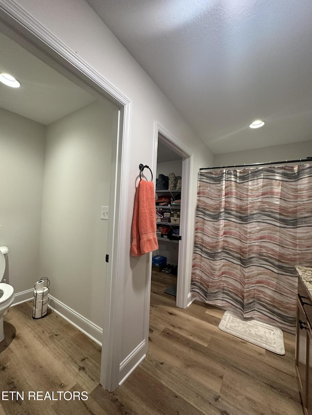 full bathroom featuring baseboards, toilet, recessed lighting, wood finished floors, and vanity