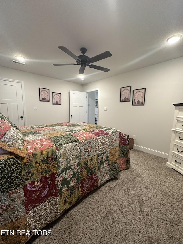 carpeted bedroom with visible vents, a ceiling fan, and baseboards