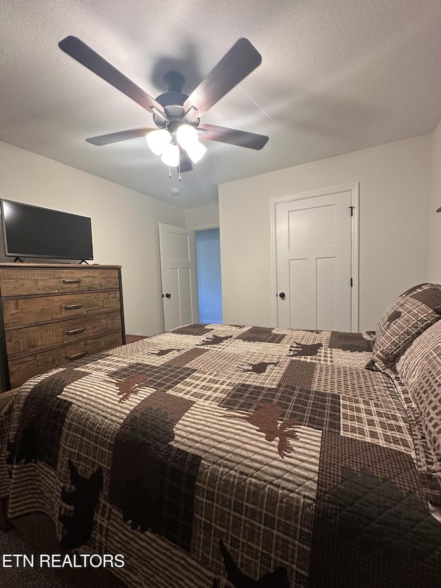 bedroom with a textured ceiling and a ceiling fan