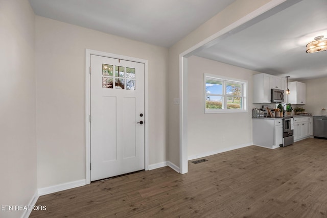 entryway featuring visible vents, dark wood-type flooring, and baseboards