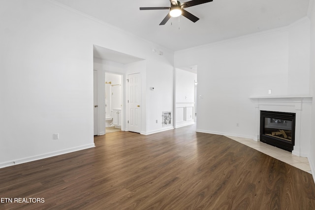 unfurnished living room with baseboards, a ceiling fan, crown molding, a fireplace with flush hearth, and wood finished floors