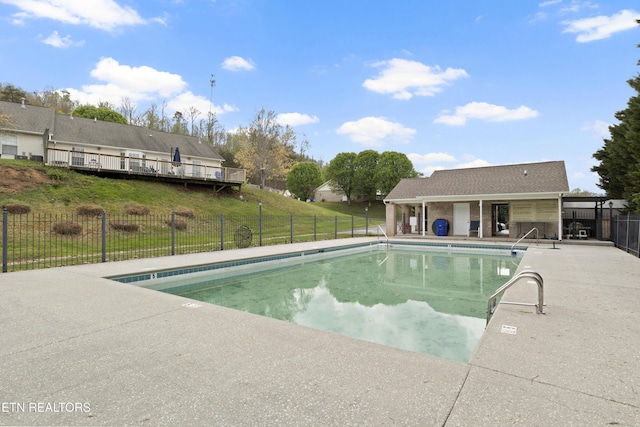 pool featuring a patio, fence, and a lawn