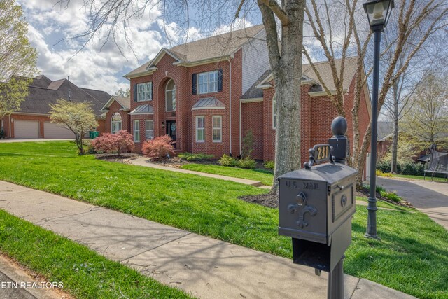 231 Gwinhurst Rd, Knoxville, TN 37934 - view of front of house featuring brick siding, a front lawn, and a trampoline