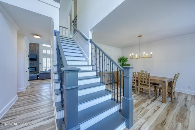 231 Gwinhurst Rd, Knoxville, TN 37934 - stairway with a notable chandelier, baseboards, a large fireplace, ornamental molding, and wood finished floors