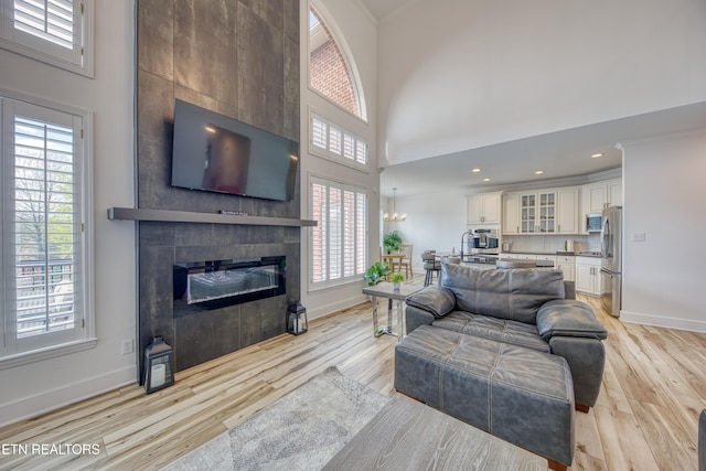 231 Gwinhurst Rd, Knoxville, TN 37934 - living room with light wood-style floors, a high ceiling, baseboards, and a large fireplace
