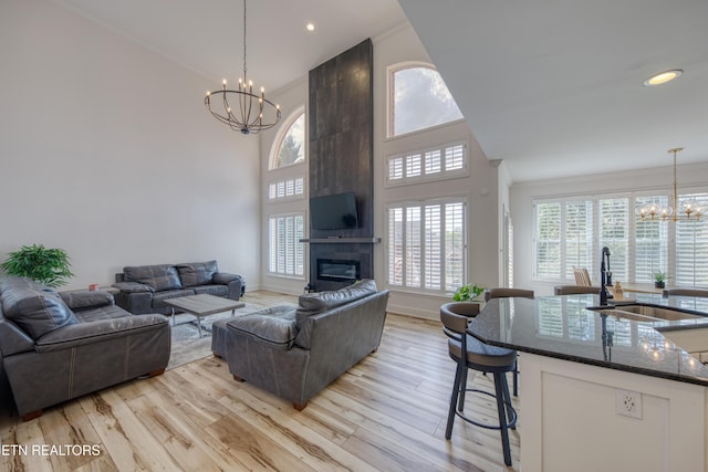 231 Gwinhurst Rd, Knoxville, TN 37934 - living area featuring a towering ceiling, an inviting chandelier, ornamental molding, a fireplace, and light wood-style flooring