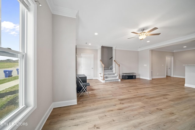 unfurnished living room featuring crown molding, ceiling fan, baseboards, stairs, and light wood-style floors