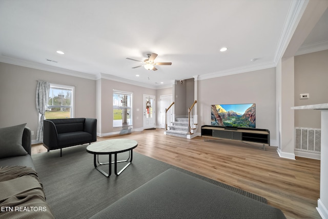 living area featuring visible vents, wood finished floors, ornamental molding, and stairway