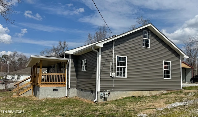 view of side of home with a yard and crawl space