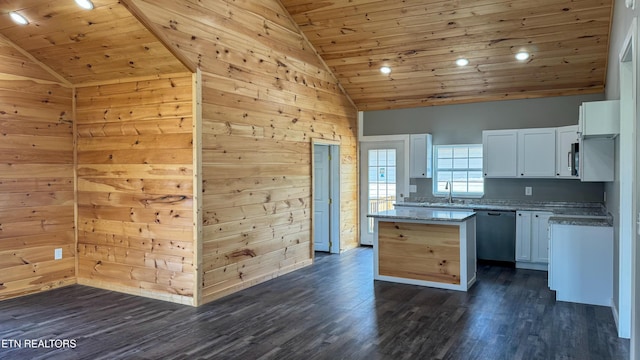kitchen featuring dishwashing machine, wood walls, wooden ceiling, and white cabinets