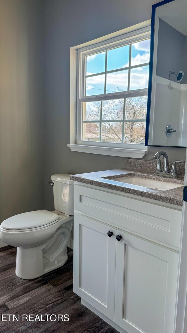 full bathroom with toilet, vanity, walk in shower, and wood finished floors