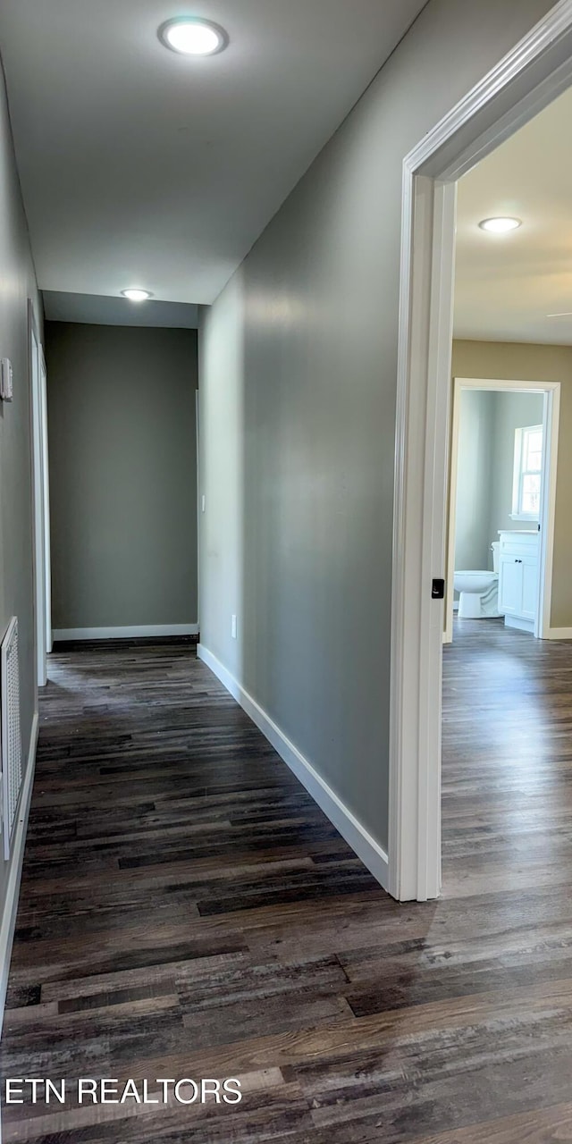 corridor with recessed lighting, baseboards, and dark wood-style flooring