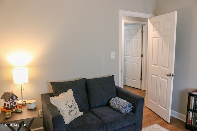 living area featuring baseboards and light wood finished floors