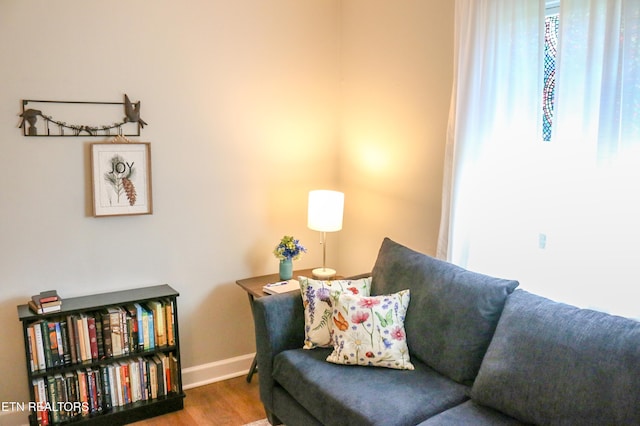 living area featuring baseboards and wood finished floors