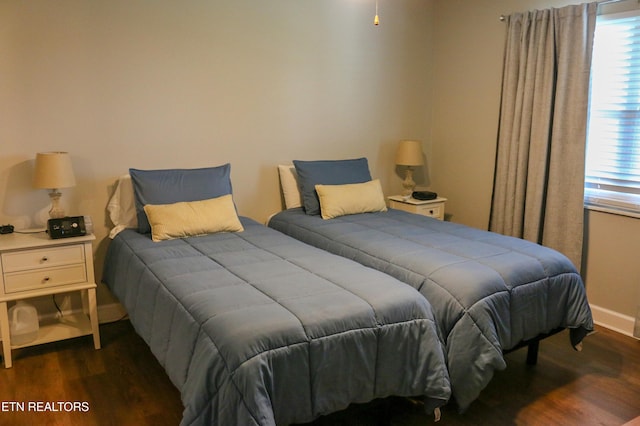 bedroom featuring baseboards and dark wood-style flooring