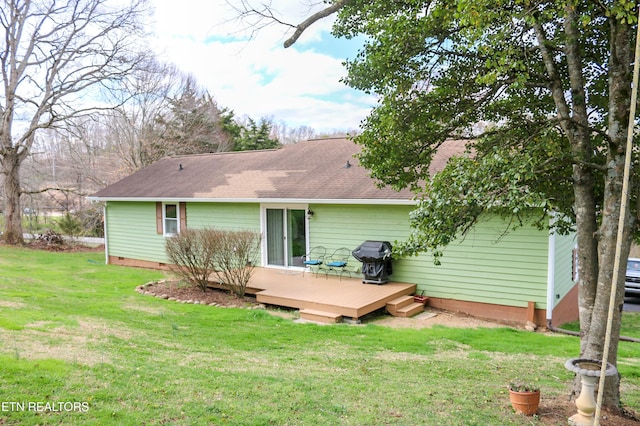 rear view of house featuring crawl space, a lawn, a shingled roof, and a deck