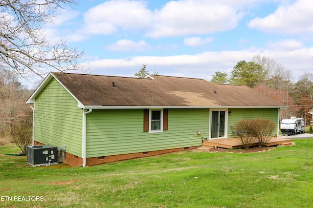 rear view of property featuring crawl space, a lawn, a shingled roof, and central AC