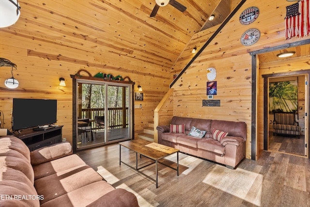 living room with wooden walls, ceiling fan, wooden ceiling, and wood finished floors