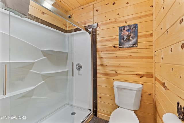 bathroom with toilet, wooden walls, and a shower stall