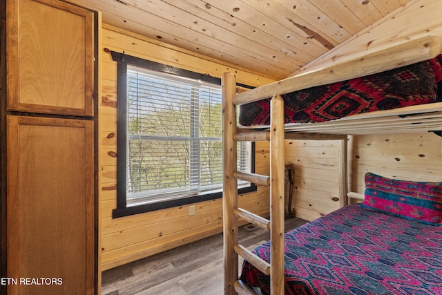 bedroom featuring vaulted ceiling, wood walls, wood ceiling, and wood finished floors
