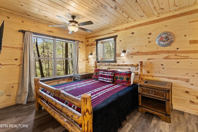 bedroom with wooden walls, wooden ceiling, and dark wood-style floors