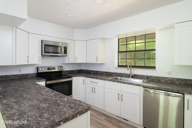 123 Manor Rd, Clinton, TN 37716 - kitchen with stainless steel appliances, a sink, white cabinetry, light wood finished floors, and recessed lighting