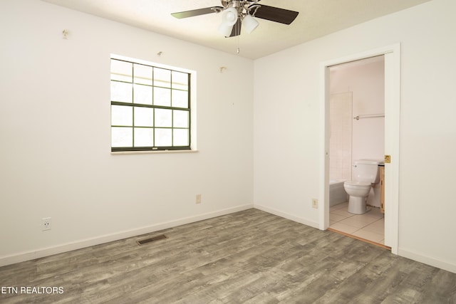 123 Manor Rd, Clinton, TN 37716 - unfurnished bedroom featuring wood finished floors, baseboards, and connected bathroom