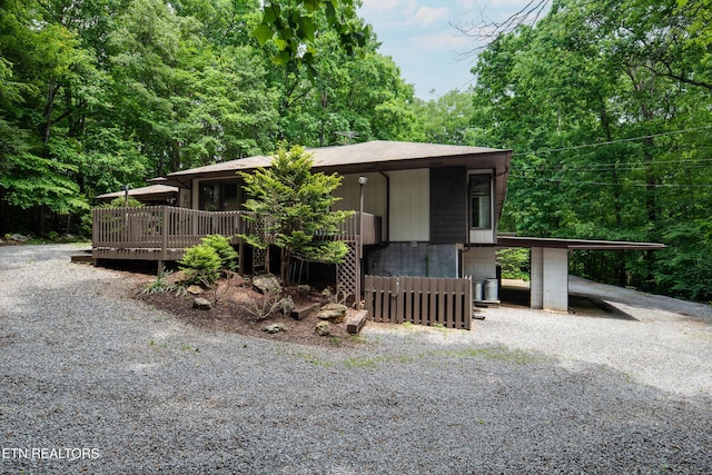 123 Manor Rd, Clinton, TN 37716 - view of front facade with a deck, a view of trees, and driveway
