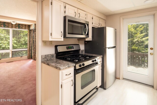123 Manor Rd, Clinton, TN 37716 - kitchen featuring appliances with stainless steel finishes, white cabinets, dark countertops, and light carpet