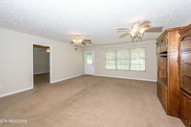 unfurnished living room featuring light colored carpet, a ceiling fan, and a textured ceiling