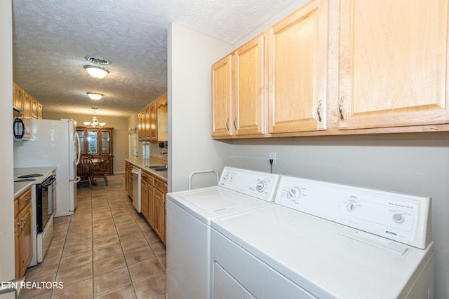 laundry room with washing machine and clothes dryer, a textured ceiling, visible vents, an inviting chandelier, and light tile patterned floors