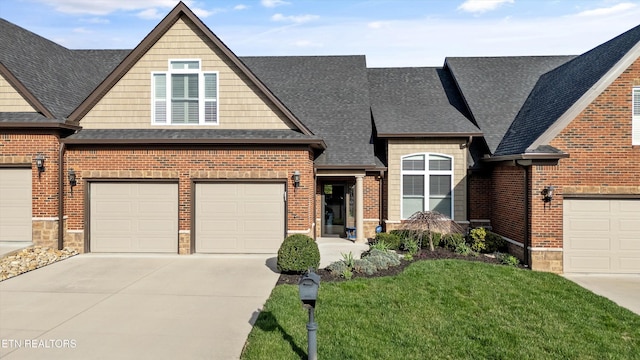 view of front of home with a front yard, brick siding, driveway, and a shingled roof