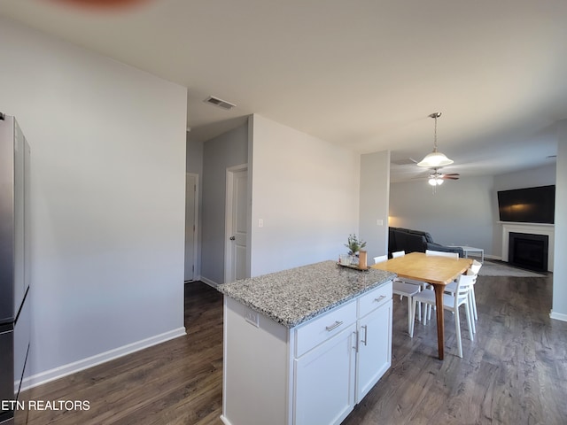 kitchen featuring white cabinetry, a ceiling fan, visible vents, open floor plan, and dark wood-style floors