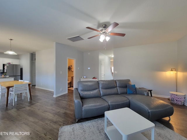 living area featuring dark wood-type flooring, baseboards, a ceiling fan, and visible vents