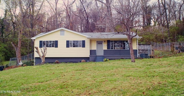 view of front of property featuring a front yard, a porch, and fence