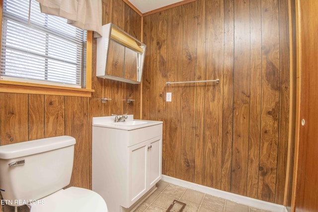 bathroom with vanity, toilet, tile patterned floors, and wooden walls