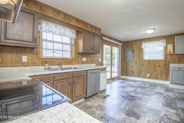 kitchen with a sink, wooden walls, stainless steel dishwasher, brown cabinets, and range with electric cooktop