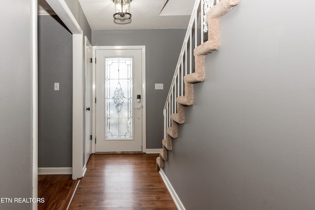 foyer with stairway, baseboards, and dark wood-style flooring