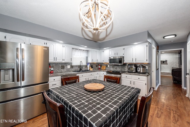 kitchen featuring white cabinetry, dark wood-type flooring, appliances with stainless steel finishes, and a sink