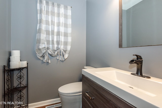 bathroom with visible vents, toilet, vanity, and baseboards