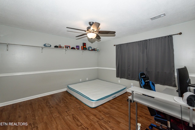 unfurnished bedroom with visible vents, a ceiling fan, baseboards, and wood finished floors
