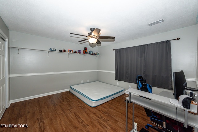 unfurnished bedroom featuring ceiling fan, wood finished floors, visible vents, and baseboards