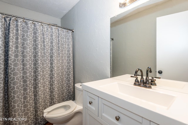bathroom with toilet, a textured ceiling, a shower with shower curtain, vanity, and a textured wall