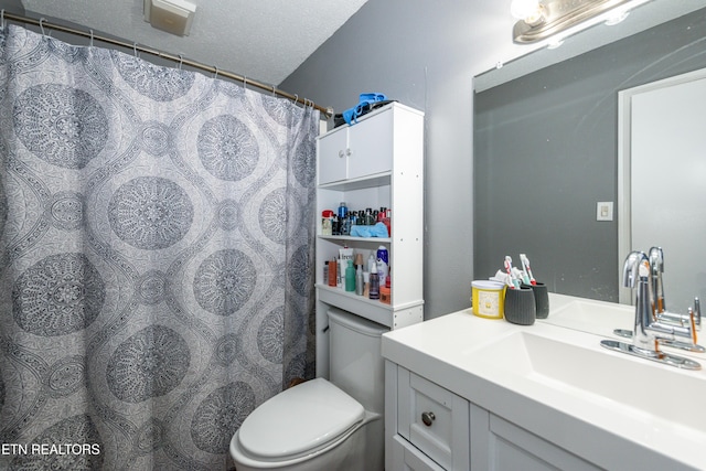 bathroom featuring vanity, toilet, and a textured ceiling
