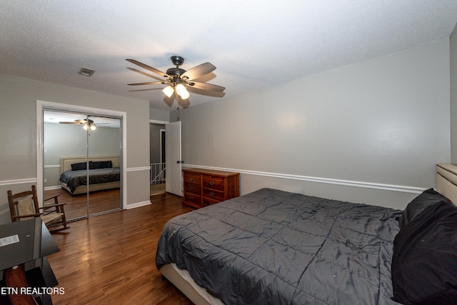 bedroom with visible vents, a ceiling fan, a textured ceiling, wood finished floors, and a closet