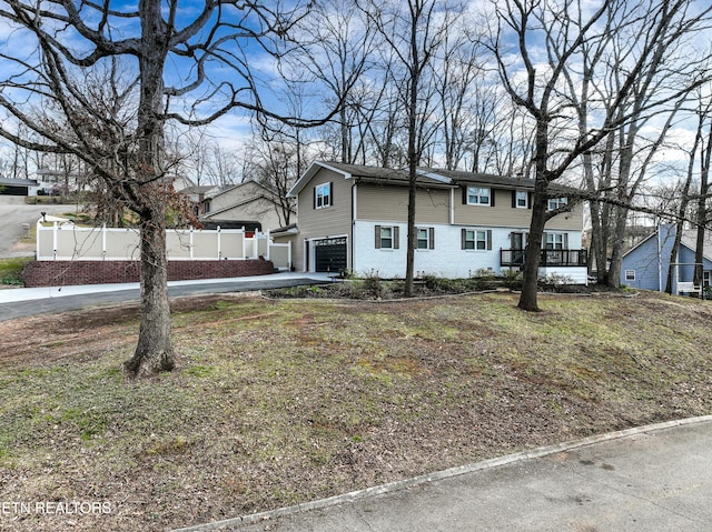 view of front facade featuring a residential view, an attached garage, driveway, and fence