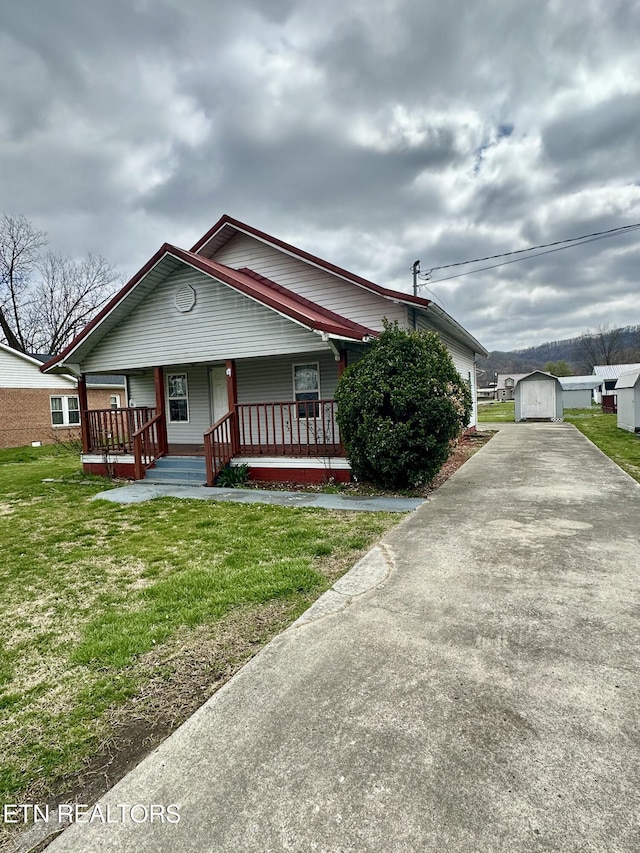 921 Winchester Ave, Middlesboro, KY 40965 - bungalow-style home with an outbuilding, a porch, concrete driveway, and a front yard
